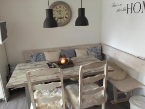 stół jadalny z krzesłami i zegarem na ścianie w obiekcie Chalet Penzn w mieście Uderns