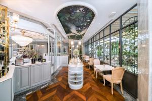 a restaurant with tables and chairs and windows at The Salil Hotel Sukhumvit 57 - Thonglor in Bangkok