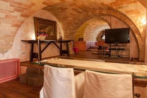 uma sala de estar com uma mesa e uma televisão em MarcheAmore - Bottega di Giacomino for art lovers, with private courtyard em Fermo