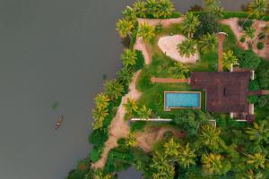 an aerial view of a house on a island in the water at Vismaya Lake Heritage in Turavūr