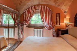 a bedroom with a bed and two windows at MarcheAmore - Bottega di Giacomino for art lovers, with private courtyard in Fermo