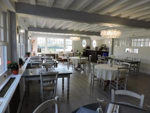 une salle à manger avec des tables, des chaises et des lustres dans l'établissement AUBERGE DE LA ROQUE, à La Roquette