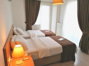 a hotel room with two beds and a table with a lamp at Tuzla Hill Suites in Tuzla