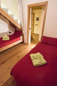 1 dormitorio con cama roja y sofá rojo en b&bTerre Aromatiche, en Chiesa in Valmalenco