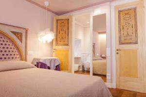 a bedroom with a bed and a room with a mirror at MarcheAmore - Stanze della Contessa, Luxury Flat with private courtyard in Fermo