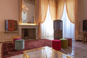 a living room with a fireplace and stools at MarcheAmore - Stanze della Contessa, Luxury Flat with private courtyard in Fermo
