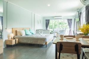 a bedroom with a bed and a dining room at THE BEACH CHA AM Suites in Cha Am