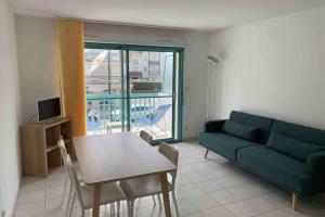 a living room with a green couch and a table at Appartement Stella-Plage in Cucq