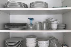uma prateleira cheia de pratos, copos e pratos em Appartement Stella-Plage em Cucq