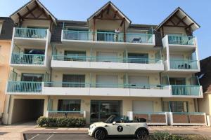 a small white car parked in front of a building at Appartement Stella-Plage in Cucq