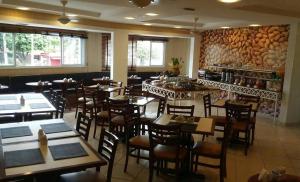 a restaurant with wooden tables and chairs in a room at Hotel Nova York in Araçatuba