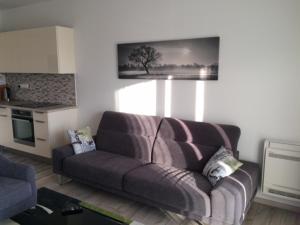 a living room with a couch and a kitchen at Part Royal Apartments in Keszthely +10 photos