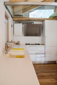 uma cozinha com armários brancos e uma grande janela em b&bTerre Aromatiche em Chiesa in Valmalenco