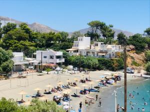 una playa con sombrillas y gente en el agua en Seaside Apartments-Angela, en Kalí Limenes
