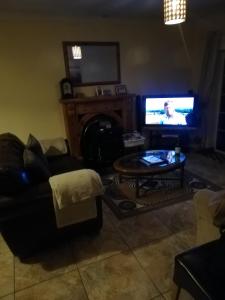 a living room with a couch and a tv and a table at Mullaghbeag Lodge in Navan