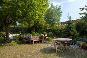 een patio met een tafel en stoelen in een tuin bij B&B t'Keygoed in Gent