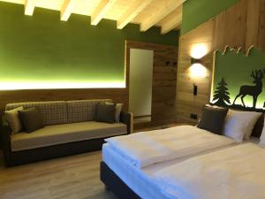 1 dormitorio con cama y sofá en Fulun Mountain Lodge, en Giustino