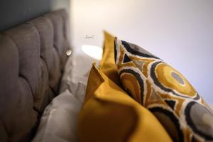 a couch with yellow and brown pillows on it at Roberts Residence in Doncaster