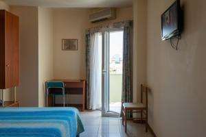 a hotel room with a bed and a sliding glass door at Hotel Gabbiano in Porto San Giorgio