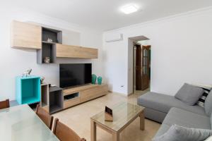 Una sala de estar con un sofá y un televisor. en Las Brisas de Puerto Rico with Jacuzzi, en Puerto Rico de Gran Canaria