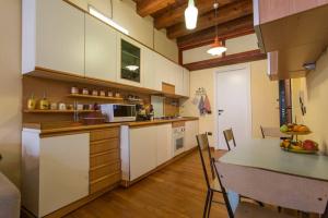 una cucina con armadi bianchi e piano di lavoro di My Lovely Home a Cagliari