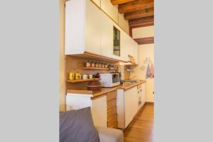 a small kitchen with white cabinets and a microwave at My Lovely Home in Cagliari +15 photos