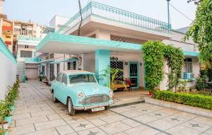 um velho carro azul estacionado em frente a uma casa em Jaipur 1727 Homestay em Jaipur