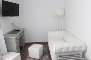 a living room with a white chair and a desk at Boutique Hostal Mistral in Cala d´Or