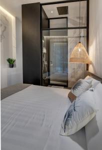 a bedroom with a large white bed with a lamp at Le Palmette Suites in Cagliari