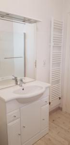 a white bathroom with a sink and a mirror at San Carlos mer in Saint-Jean-de-Luz