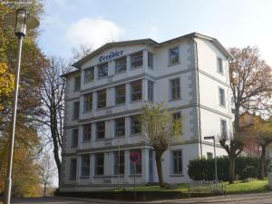 Biały budynek z napisem w obiekcie Haus Seeadler Wohnung Habicht w Zinnowitz