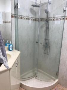 a shower with a glass door in a bathroom at הבית בגן in Gan Yavne