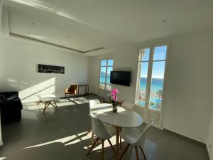 a living room with a table and chairs and the ocean at 219 Promenade in Nice
