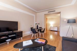 uma sala de estar com um sofá e uma mesa em Milan Royal Suites - Centro em Milão