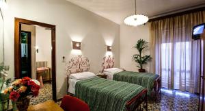 a hotel room with two beds and a mirror at Hotel Villarosa con Vespa Rent in Sarroch +34 photos