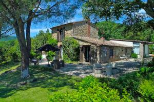 une maison en pierre avec un jardin en face dans l'établissement Il Falco - Rustico-Villa mit privatem Pool in Alleinlage, à Caldana
