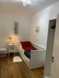 um pequeno quarto com uma cama com um cobertor vermelho em Wieko Ferienwohnungen - Luxus pur im Prinz von Preußen, Erdgeschoss em Bad Elster