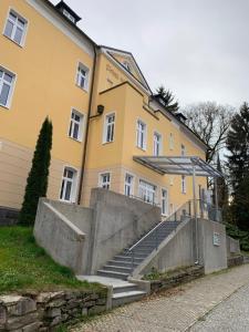 a yellow building with stairs in front of a building at Wieko Ferienwohnungen - Luxus pur im Prinz von Preußen, Erdgeschoss in Bad Elster