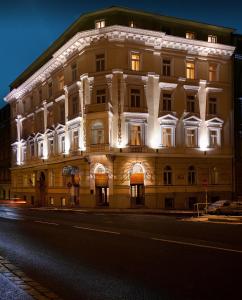 a lit up building on a street at night at Hotel Kinsky Fountain in Prague