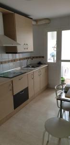 a kitchen with white cabinets and a sink and a table at Apartamento en Puerto de Roquetas de Mar in Roquetas de Mar