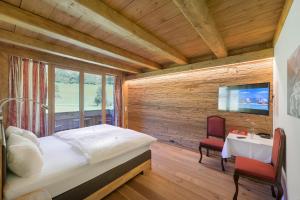 sypialnia z łóżkiem, stołem i telewizorem w obiekcie Golf- und Sporthotel Moarhof w mieście Walchsee +37 zdjęć