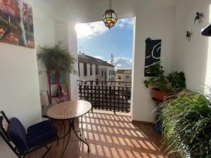 a balcony with a table and chairs and a window at Vivienda turistica Pop Bowie House in Úbeda