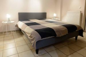 a bed in a room with two tables and two lamps at 50 M Kerameikos Metro Cosy Luxury Apartment in Athens