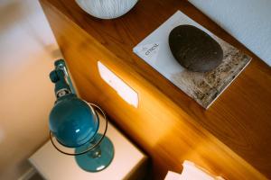 a nightstand with a green lamp and a rock on it at el gran sueño Boutique Hotel & Apartamentos - Adults Only in Pintueles