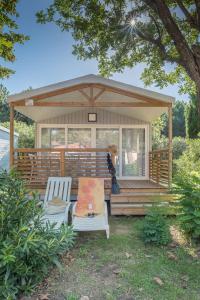 un cenador con 2 sillas y una mesa de picnic en un patio en Camping Le Méditerranée Argelès - Domaine piétonnier en Argelès-sur-Mer