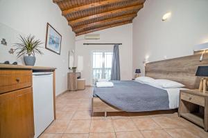 1 dormitorio con 1 cama grande y cocina en Trabukos Beach Complex, en Kavos