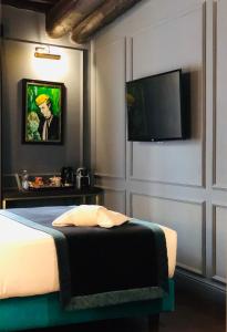 a bedroom with a bed and a flat screen tv at Saint B Boutique Hotel STB in Rome