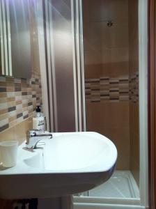 a bathroom with a white sink and a shower at La Casa del Maestro in Rabanal