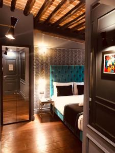 um quarto com uma cama com uma cabeceira azul em Saint B Boutique Hotel STB em Roma