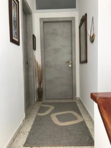 a hallway with a door with a carpet with the letter b on it at הבית בגן in Gan Yavne